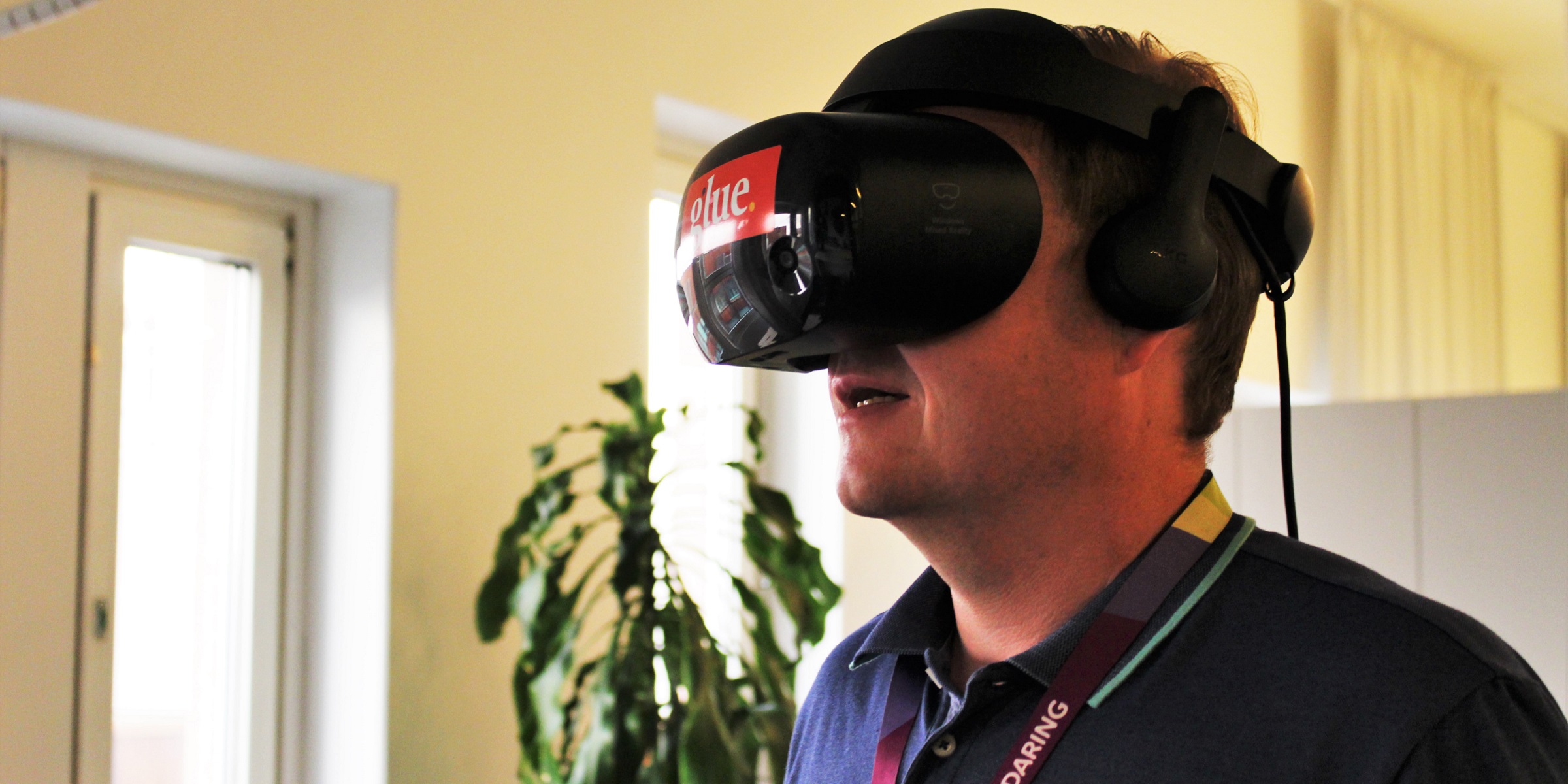 Henkilö osallistuu virtuaalikokoukseen päässään VR-lasit