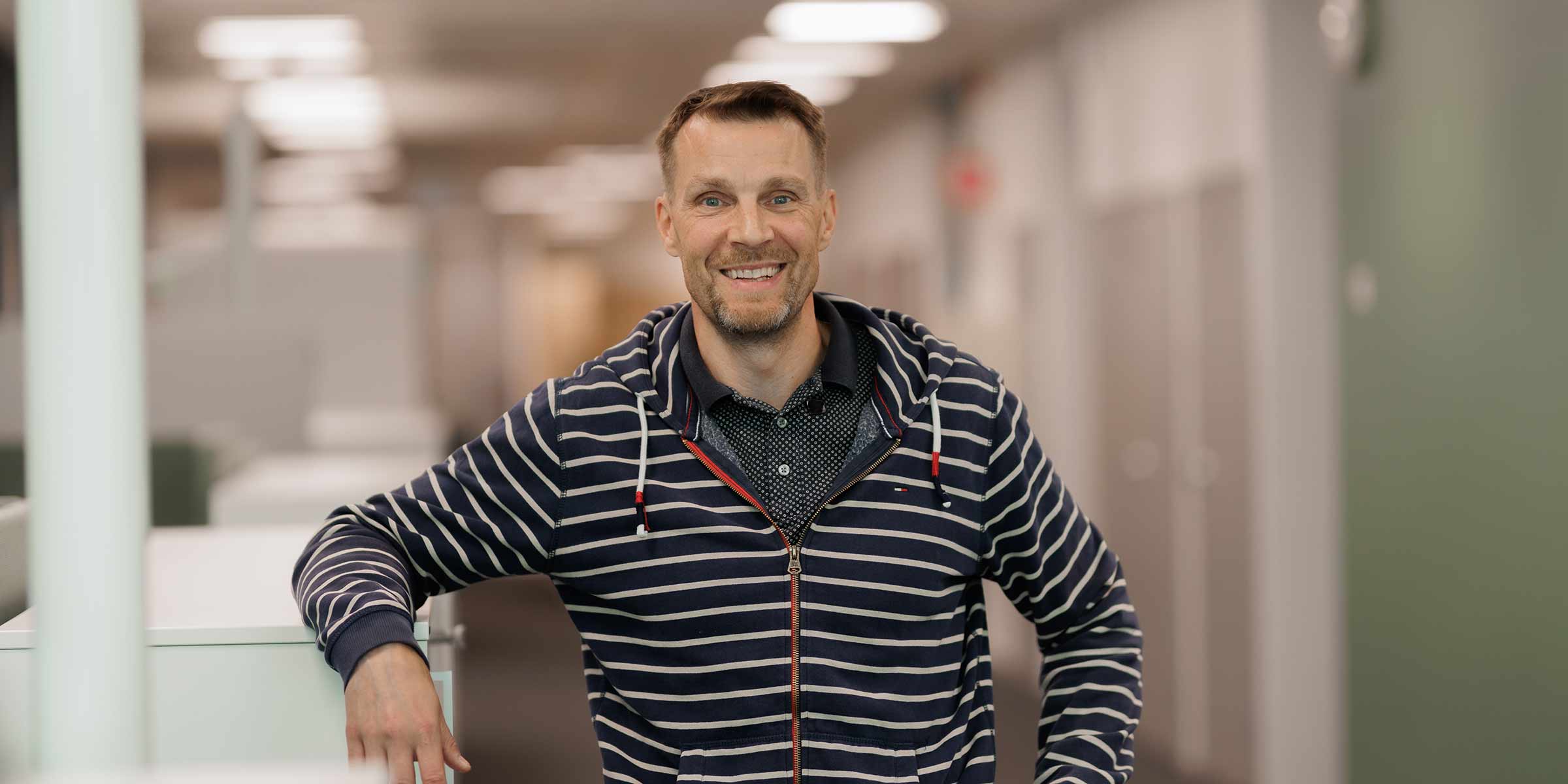 Tarmo Hassinen hymyilee toimistolla