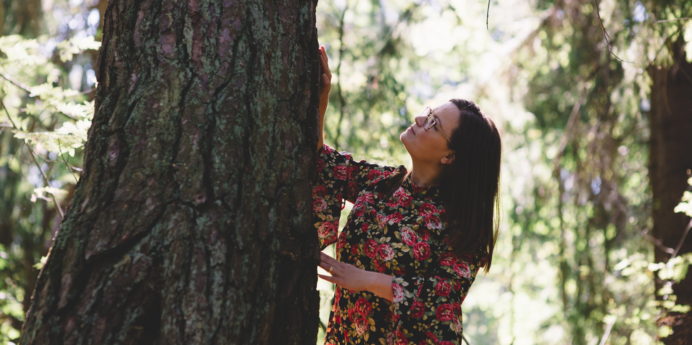 Mindstone-yrityksen perustaja Jonna Huomo silittää puuta metsässä.