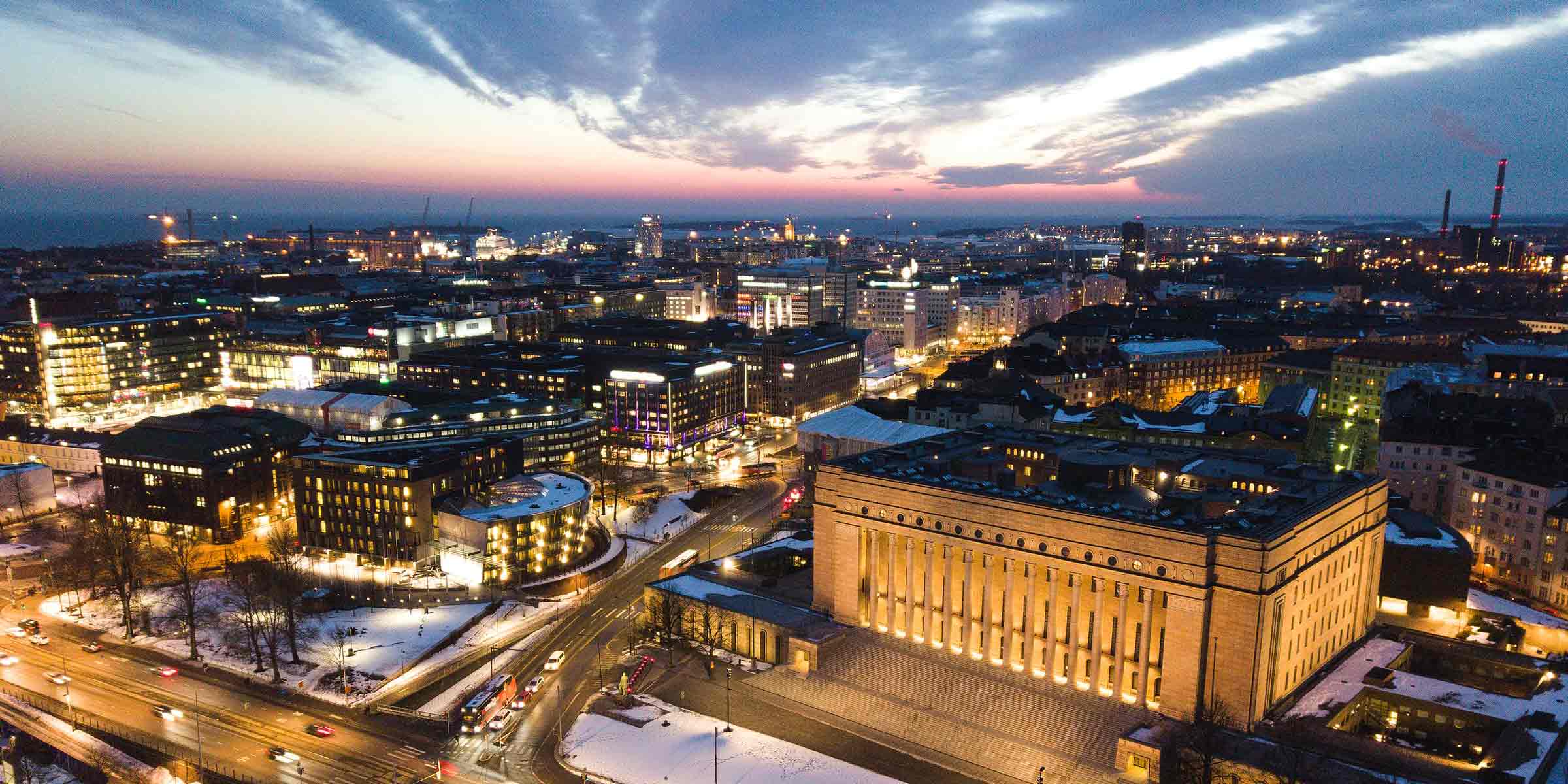 Öinen ilmakuva Helsingistä, etualalla eduskuntatalo ja taaempana meri.