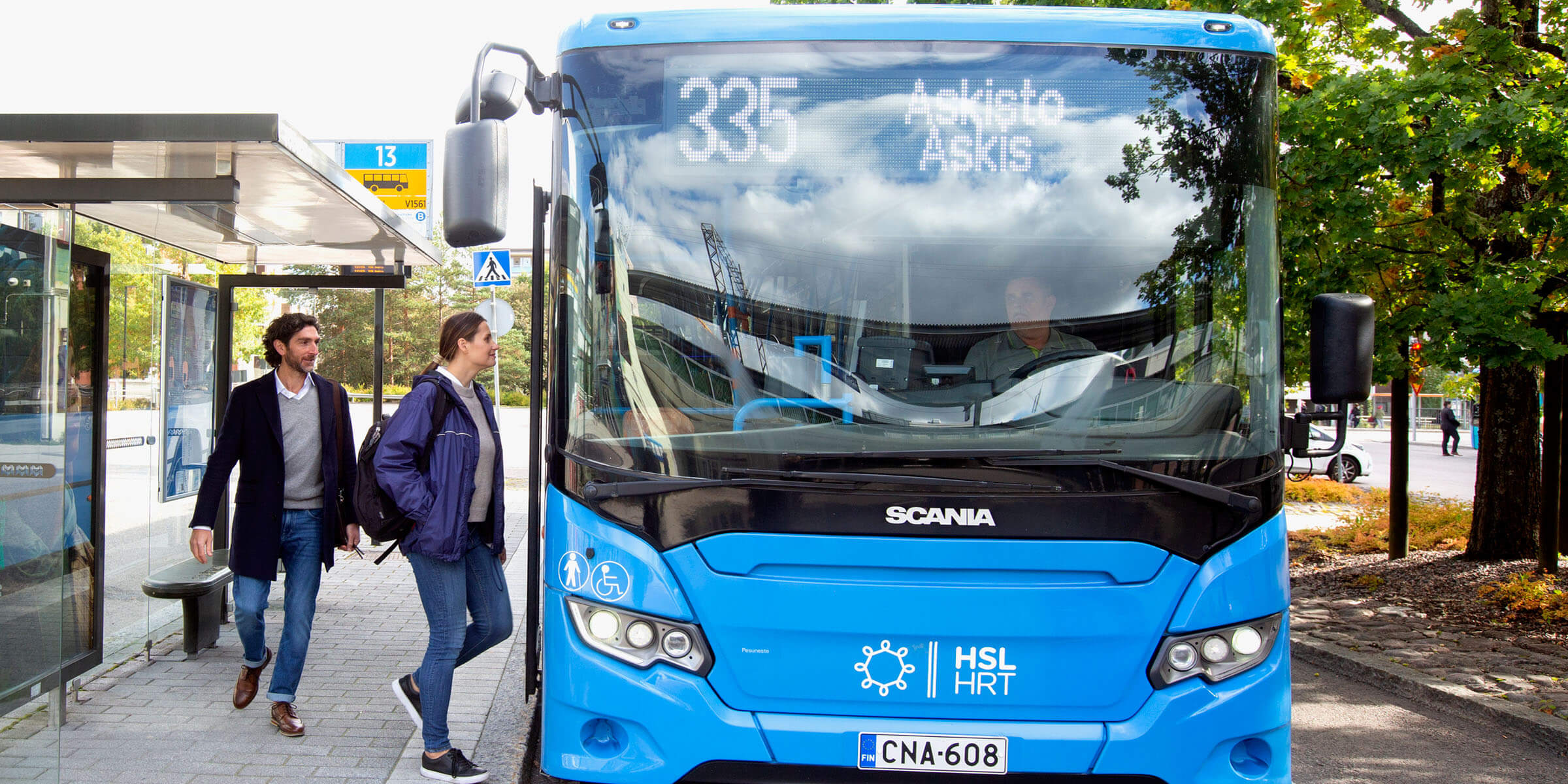 Nainen ja mies nousevat Helsingissä HSL:n bussiin