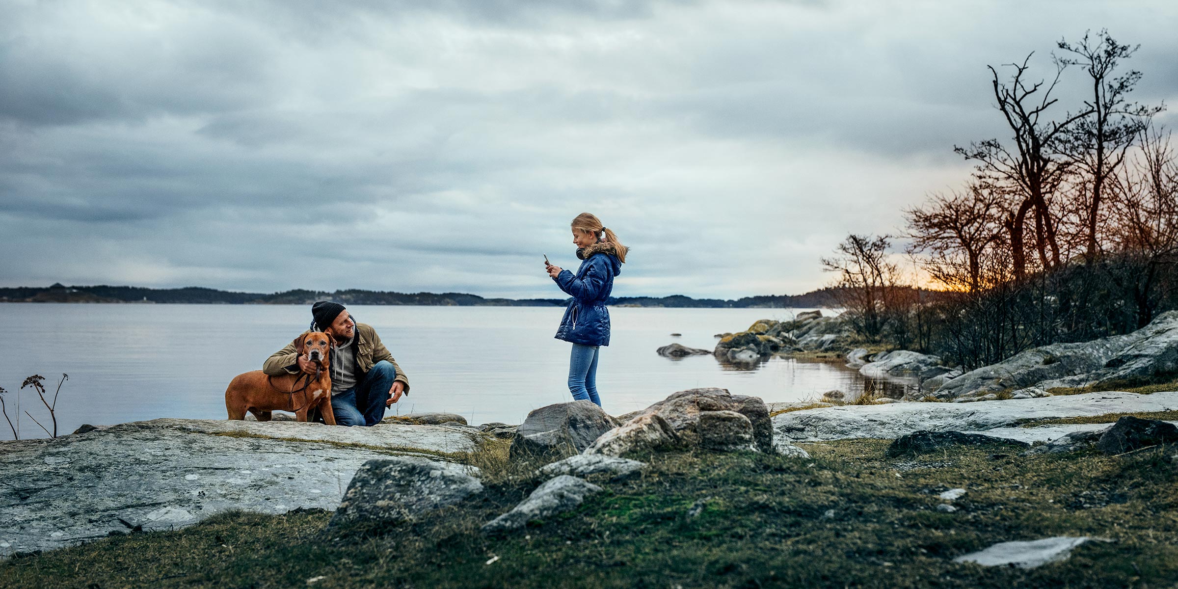 Nainen rannalla katsoo puhelinta.